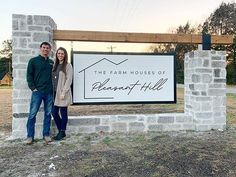 two people standing in front of a sign for the farm houses of pleasant hill