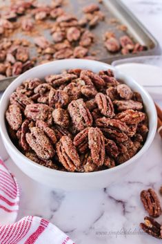 a white bowl filled with pecans sitting on top of a counter