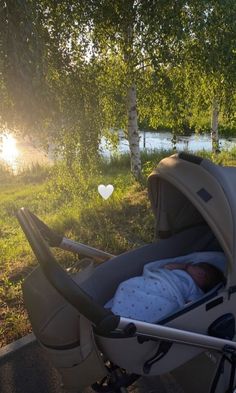 a baby is sleeping in a stroller on the side of the road near some trees