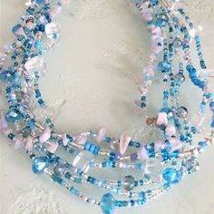 Artisan Czech Glass Bead 6 Strand 18" Long Fashion Statement Necklace Lt. Blue & Crystal A Total Length Of 18" Long, With Glass Beads & Semi Precious Stone Chips. Easy To Open/Close Magnetic Clasp. One Of A Kind Necklace Handcrafted/No Two Are Exactly Alike Czech Glass Beads Are Know World Wide For Their Quality, Vibrant Colors Handmade In Guatemala Using Artisan Crafted Czech Glass Beads. Principles Of Fair Trade Are Upheld. Handmade Light Blue Multi-strand Jewelry, Blue Round Beaded Glass Crystal Necklace, Blue Glass Crystal Necklace With Round Beads, Blue Crystal Necklaces With Round Glass Beads, Blue Czech Glass Beads For Beach, Bohemian Blue Czech Glass Necklaces, Blue Jewelry With Silver Beads For The Beach, Blue Glass Beaded Bohemian Necklace, Blue Glass Bohemian Beaded Necklaces