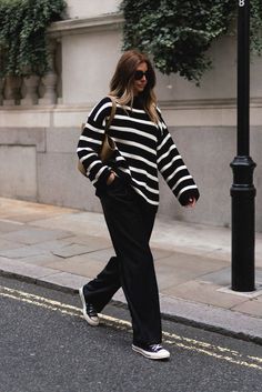 Emma Hill style. Black and white striped oversized jumper, Little Liffner Tall Tulip tote bag, black wool wide leg tailored pleat front trousers, black Converse Chuck 70 high tops, Celine Baby Audrey sunglasses. Casual transitional Autumn Spring monochrome outfit. Black White Stripe Jumper Outfit, Emma Hill Winter Outfits, Oversized Black Jumper Outfit, Winter Stripes Outfit, Black Striped Jumper Outfit, Casual Outfits Black And White, Autumn Outfits Trainers, Emma Hill Outfits, Black Trousers Autumn Outfit