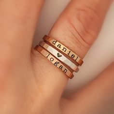 Mother's Day Gift | Pick and choose names, dates, or symbols for a three stackable ring set!  What an amazing way to commemorate an event or honor those who are important to you! See photos for examples. These rings are handmade in our Indiana studio. Each engraved ring starts from a spool of wire. They are handcut, handformed and soldered in the first process of creating your ring. They are then hammered to size, engraved, handbrushed, and polished. Each ring will have a small solder spot in th Mom Rings Stackable, Name Rings Personalized, Personalized Stackable Rings, Stackable Name Rings, Stackable Ring Sets, Typewriter Font, Mom Ring, Name Ring, Engraved Ring