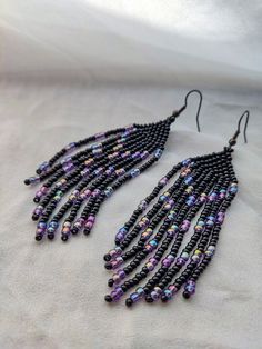 black beaded earrings with purple and blue beads hanging from the end of each ear