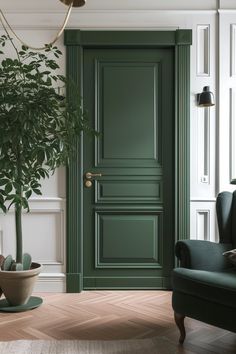 a living room with a green door and two chairs in front of the door is a potted plant