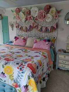 a bed with flowers on the headboard and pillows