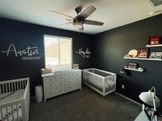 a baby's room with black walls and white furniture