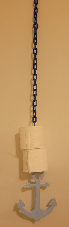 an anchor is hanging on the wall next to a toilet paper roll