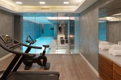 an exercise room with a treadmill, towel rack and large mirror on the wall