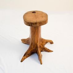 a small wooden table sitting on top of a white sheet covered floor next to a tree stump