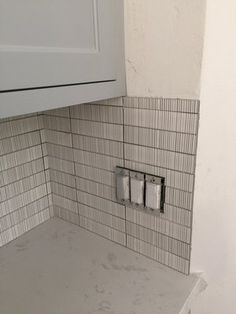 a kitchen with white cabinets and tile backsplashes on the counter top area