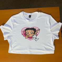 New Without Tags! This Item Is A Really Cute Graphic Tee Of Betty Boop And Her Dog, It Is Unbranded. The Size Is 3xl, But If You Have A Larger Chest This Might Fit Too Short. It Is Very Stretchy. This Top Is 19 Inches Across The Chest And 17 1/2 Inches Long. Feel Free To Message Me For More Info :) Y2k White Top With Cartoon Print, White Y2k Cartoon Print Top, Trendy White Cartoon Print Top, Trendy White Top With Cartoon Print, Trendy White Tops With Cartoon Print, White Cotton Tops With Cartoon Print, Cute White Short Sleeve Crop Top, Cute White Crew Neck Crop Top, White Graphic Tee With Cartoon Print