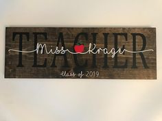 a wooden sign that says teacher with an apple on it