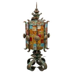 a decorative lamp with multiple colors and designs on it's sides, hanging from the ceiling