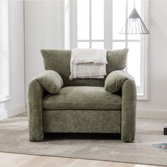 a green chair sitting in front of a window with pillows on it's back