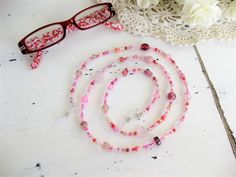 "This Pink Eyeglass Chain can also be worn as a necklace. Ralston Originals was the first to add the lobster clasp at the end of the eyeglass chain to join it together to make a Necklace. Brilliant! This makes it even more convenient because you now have two pieces of jewelry in one, and eyeglass chain for your glasses, and a beaded necklace!! The chain is made with an assortment of sizes and colors of pretty pink glass beads, and pink seed beads. The ready made chain is 26 or 32 inches long, or Glass Beads Gift, Round Glass Beads For Gifts, Adjustable Clear Beaded Necklace For Gifts, Adjustable Clear Beaded Necklaces As Gifts, Pink Glass Beaded Necklaces For Gift, Pink Glass Beaded Necklace For Gift, Adjustable Pink Glasses Chains As Gift, Single Strand Glass Beaded Necklace For Gift, Glass Beaded Single Strand Necklace For Gift