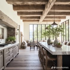 a large kitchen with wooden floors and white counter tops next to a dining room table