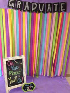 an image of graduation party decorations with streamers on the wall and a chalkboard sign