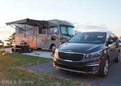 a car parked next to a camper with an rv on the road behind it