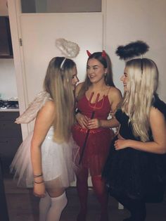 three girls dressed up in costumes talking to each other