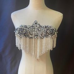 a white mannequin with black and silver beading on it