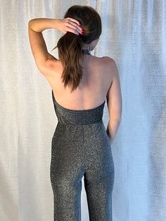 Take your holiday look to the next level this jumpsuit. Featuring a black material with a silver sequins, a cowl neck design and a flared fit, how could you resist? Pair with high heels and silver accessories to elevate the vibe! Sleek Sleeveless Jumpsuit For Party, Sleek Strapless Sleeveless Jumpsuit For Party, Fitted Disco Jumpsuits And Rompers For Evening, Fitted Shimmer Jumpsuits And Rompers For Night Out, Fitted Shimmer Jumpsuits For Night Out, Elegant Fitted Jumpsuits And Rompers With Shimmer, Elegant Fitted Shimmer Jumpsuits And Rompers, Shimmer Jumpsuits And Rompers For Party Season, Shimmer Jumpsuits And Rompers For Evening Parties