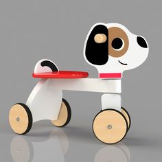 a wooden toy with wheels and a dog face on the top, sitting in front of a gray background