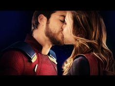 a man and woman kissing each other in front of a blue background with the superman logo on it