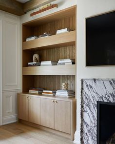 a living room filled with furniture and a flat screen tv mounted on a wall next to a fireplace