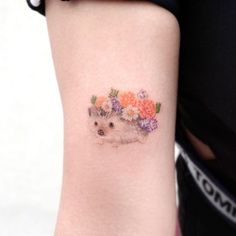 a small dog with flowers on it's arm