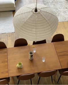 an overhead view of a dining room table and chairs with umbrella over it in the background