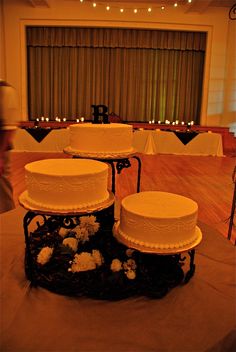 three tiered wedding cake sitting on top of a table in front of a stage