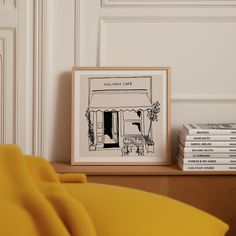 a yellow chair sitting next to a stack of books on top of a wooden table