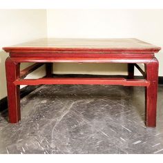 a red coffee table sitting on top of a gray floor