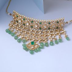 Description This silver choker necklace by Paksha is expertly created from an array of Moissanite stones in mixed classic cuts and high-quality CZ stones. Finished with a gold-tone plated, highlighting its beautiful hues and rich yellow tones, this necklace makes a grandeur and luxury statement. It is crafted with beautiful green precious beads. This choker necklace is part of the Rasika family, designed by Paksha experts. Style this on your special day for grand rich look. Product Information M Kundan Jewellery Bridal, Indian Bridal Jewelry Sets, Jewellery Design Sketches, Gold Jewelry Simple Necklace, Antique Jewellery Designs, Silver Choker Necklace, Precious Beads, Gold Jewelry Earrings, Diamond Necklaces