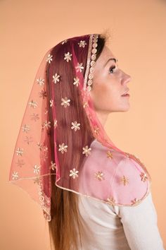 a woman with long red hair wearing a pink veil and flowered headdress