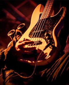 a close up of a person holding a bass guitar