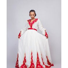 This Habesha dress is a true work of art, made of soft and luxurious Menen fabric in a regal red color. The dress features a stunning Tilf embroidery design, covering the entire dress with intricate patterns and designs that are unique to Ethiopian traditional clothing. The Tilf embroidery adds a touch of elegance and sophistication to the dress, featuring delicate patterns and designs that are sure to turn heads. The dress is designed with a fitted bodice that accentuates the waistline and flar Traditional Fitted V-neck Dress, White Long Dress For Festive Occasion, Ceremonial Floor-length Gown, Traditional Red Floor-length Dress, Red Floor-length Gown For Traditional Ceremonies, Traditional Red Maxi Length Dresses, Red Festive Long Gown, Festive Red Long Gown, Ceremonial Long Sleeve Dresses For Festivals