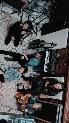 a group of people standing next to each other in front of a keyboard and music equipment