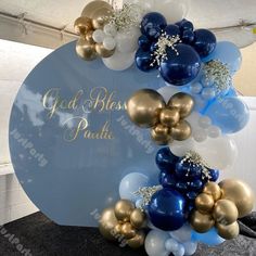 a balloon arch with gold, blue and white balloons on it that says god & bliss pastel