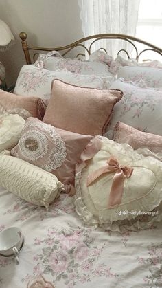 a bed with pink and white pillows on top of it