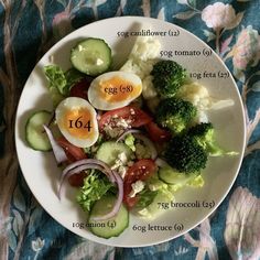 a white plate topped with vegetables and hard boiled eggs