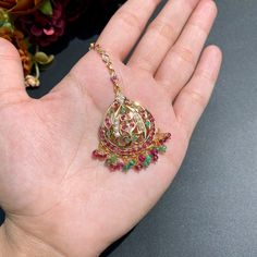 Featured is a small mang teeka in 22k gold studded with rubies, emeralds and pearls. The teeka's chain is approx 4inches in length and has a hook at the end. The teeka weighs 9.82 gms including 0.86 gms in the hanging ruby-emerald beads. Price Breakup Summary Component Rupees % of Total 22k Gold 43,806 76.5% Stones & Beads 3,918 6.8% Making Charges 7,885 13.8% Taxes (GST) 1,668 3.0% Total 57,278 100.0% View Detailed Price Breakup Watch Video Here 22k Gold Tilla Jewelry For Puja, Festive Gold Plated Tikka As A Gift, Festive Yellow Gold Kundan Tikka, Temple Jewelry Tikka With Intricate Design As Gift, Festive Yellow Gold Tikka With Tilla, Festive Yellow Gold Tilla Tikka, Gold Temple Jewelry Tikka As Gift, Yellow Gold Temple Jewelry Tikka For Festive Occasions, Hand Set 22k Gold Jewelry For Puja