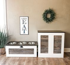 two dog bowls are sitting next to each other in front of a sign that says let's eat