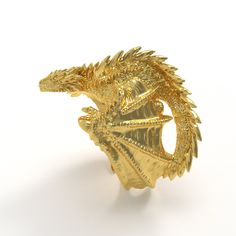 a gold dragon ring on a white background