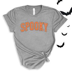 Spooky graphic in a varsity orange and white font. Perfect for this spooky season! Wear to school dress up days, Halloween parties, or just around town for halloween spirit! For All Varsity Spooky T-shirts click here to view.For Adult & Youth Varsity Spooky Sweatshirts click here to view. Adult Sizes S-XXL (unisex sizing)Youth Sizes S-XL (unisex sizing)Toddler Sizes 2T, 3T, 4T (unisex sizing) Bella + Canvas (Adult, Youth & Toddler)4.2 oz. Airlume combed and ring-spun cottonPre-shrunkFor a more relaxed fit, size up! Spooky Orange T-shirt For Fall, Trendy Fall T-shirt For School, Orange Halloween T-shirt With Letter Print, Trendy Halloween Text Print T-shirt, College Fall T-shirt With School Spirit, Halloween Slogan T-shirt For Streetwear, College Letter Print T-shirt For Fall, Varsity T-shirt For College In Fall, School Crew Neck T-shirt For Fall