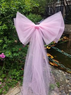 a pink bow hanging from the side of a fence