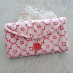 a pink and white purse sitting on top of a table next to a piece of paper