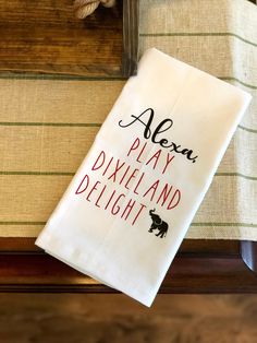 a white dish towel with the words alexn play dixieland delight printed on it