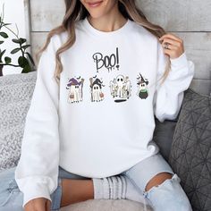 This Halloween, get ready to show off your spooky vibes with this groovy ghost-themed sweatshirt! Featuring cute ghosts, witches, and other spooky characters, this sweatshirt is perfect for the spooky season. The bright colors and fun designs will make you look cute and stylish while still embracing the spirit of Halloween. Trick or treat in style with this spooky ghost-themed sweatshirt! The perfect way to show off your love of all things spooky, creepy, and boo-tiful. Get ready to have a happy White Character Print Hoodie For Fall, Fun White Hoodie For Fall, Trendy Fall Hoodie With Character Print, Trendy White Halloween Hoodie, Fun Long Sleeve Sweatshirt With Character Print, Cute White Fall Sweatshirt, Cute White Sweatshirt For Fall, Fun White Sweatshirt For Loungewear, Oversized White Halloween Sweater