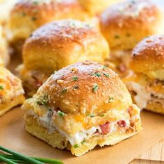 several mini sandwiches on a cutting board with asparagus